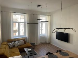 Una sala de estar con un sofá y un televisor. en Residence Drobného apartmán Park, en Brno