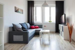 sala de estar con sofá azul y TV en Apartament Wały Chrobrego, en Szczecin