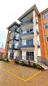 a building with a parking lot in front of it at 2 Bedroom Spacious Kampala Buwate Stay A few Steps from the Mall in Buwate