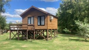 ein Haus auf Holzpfählen im Gras in der Unterkunft Reserva Otto in Zárate