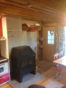 a living room with a stove in a kitchen at Ranta Äärelä in Vuotso