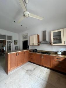 a kitchen with wooden cabinets and a ceiling fan at Nora Lyn - Colombo in Colombo