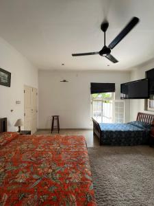 a large bedroom with a bed and a ceiling fan at Nora Lyn - Colombo in Colombo