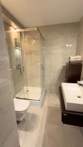 a bathroom with a shower and a toilet and a sink at Harbor Apartment in Ustka