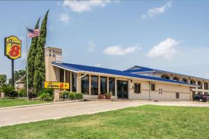 a building with an american flag in front of it at Super 8 by Wyndham San Marcos in San Marcos