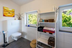 a white bathroom with a toilet and a window at Ferienhaus Ostroher Moor in Ostrohe +18 photos