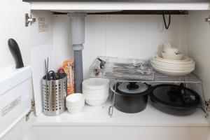 una cocina con platos y platos en un estante en Ocean 西九条, en Osaka
