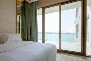 a bedroom with a bed and a large window at Kyona Marina in Jeddah