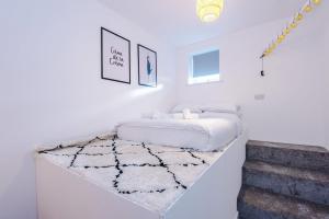 Un dormitorio blanco con una cama y una escalera. en Cohost Partners Chic Stay Heart of Warrington, en Warrington