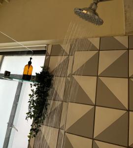 a bathroom with a tiled wall and a window at I Know a Spot! In Johannesburg in Johannesburg