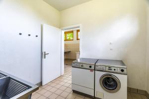 a laundry room with a washer and dryer in it at Gästehaus auf Camping Grächbiel in Grächen