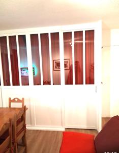 a living room with a large white cabinet with windows at Super Besse chez Sophie 2ch, séjour, wifi, 2tv, rdc, terrasse, parc, piscine, pkg in Besse-et-Saint-Anastaise +36 photos