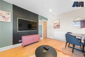 a living room with a table and a tv at 2 Bed Sleeps 4 in Dunfermline in Cairneyhill