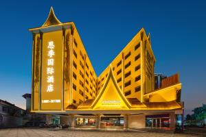景洪市西双版纳景洪恩季国际酒店的一座黄色的大建筑,写着