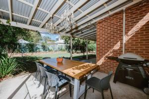 un patio con tavolo, sedie e griglia di Carinya - Federation Cottage in Central Mudgee a Mudgee