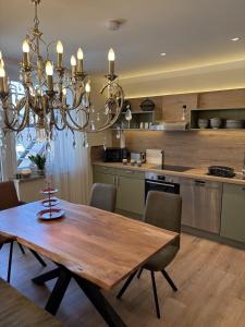 a kitchen with a wooden table and a chandelier at das CHRISTO – Ferienwohnungen im Herzen der Kneippstadt in Bad Wörishofen +13 photos