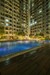 a large swimming pool at night with tall buildings at Tobe in Hue 1 - Cozy Apartment with Pool and Gym & City View in Thôn Văn Dương
