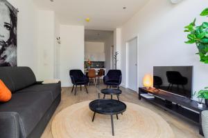 ティルブルフにあるFast Wifi, Vibrant Home, 10 Min From Eftelingのソファと椅子とテレビのあるリビングルーム