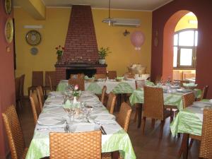 a dining room with tables and chairs and a fireplace at Agriturismo Rajata in Bagheria