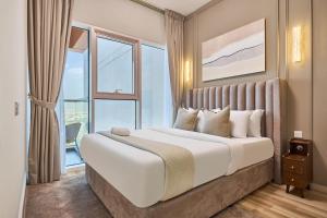 Modern High-Floor 1BR Apartment with Balcony, Pool Access & Golf Course View, Up to 4 Guests, by Stayfinity في دبي: غرفة نوم بسرير كبير مع نافذة كبيرة