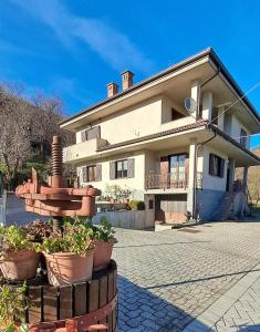 a house with a fountain in front of it at Rubattiera casa vacanze in Roccasparvera