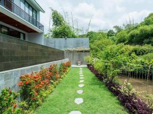 un jardin avec une passerelle en face d'un bâtiment dans l'établissement Villa Sanur river view, à anur