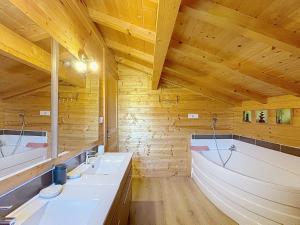 a wooden bathroom with two sinks and two mirrors at Chalet du Géhan in Cornimont +19 photos