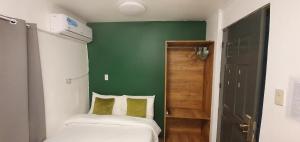 a bedroom with a green wall and two beds at AJ Tourist Inn in Coron