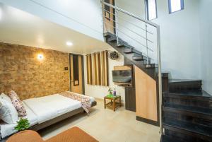 Cette petite chambre comprend un lit et un escalier. dans l'établissement The Sangam Hotel, à Mahabaleshwar