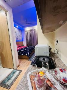 グレーター・ノイダにあるFabHotel Elegant Stayのベッド1台、テーブル(ワイングラス付)