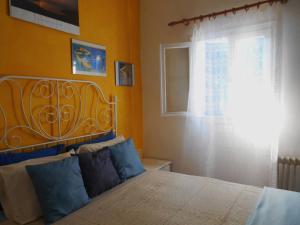 a bedroom with a bed with blue pillows and a window at Meltemia Studio Samos with pool in Kámpos