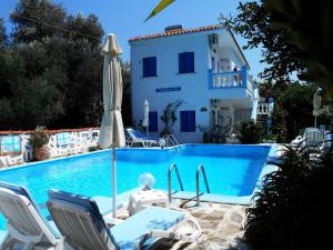 a pool with chairs and a house in the background at Meltemia Studio Samos with pool in Kámpos