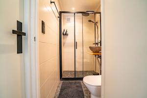 a bathroom with a shower and a toilet at Boshuisje Rekem - Topo in Lanaken