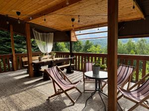 patio con 2 sedie e tavolo su una terrazza di Rudera u Sióstr DREWNIANY DOMEK Stróża a Stróża