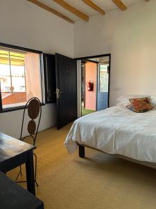 a bedroom with a bed and a table and a window at atlas lodge in Amizmiz