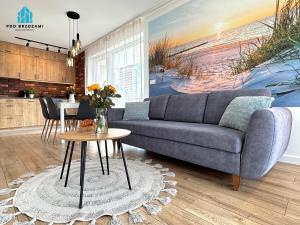 a living room with a couch and a table at Pod Brzozami Apartamenty Gąski in Gąski