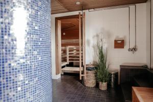 a bathroom with a shower with blue tiles on the wall at Original Sokos Hotel Rikala Salo in Salo +34 photos