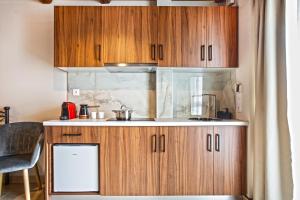 a kitchen with wooden cabinets and a counter top at Spiliara-Apartments in Axós