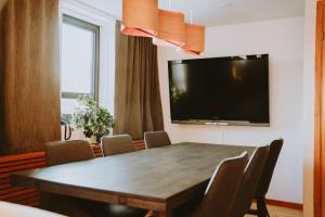 a dining room with a table and a flat screen tv at Original Sokos Hotel Rikala Salo in Salo