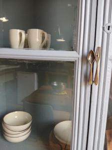 une armoire en verre avec des bols et des ustensiles dans l'établissement Apartamento Luz, à Órgiva