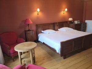 een slaapkamer met een bed, een tafel en een stoel bij Maison d'hôtes Coeurdacier in Monthureux-sur-Saône