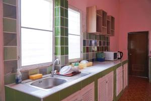 una cucina con un lavello e due finestre di ตาลฟ้ารีสอร์ท (Tanfah Resort) a Ban Nong Khang