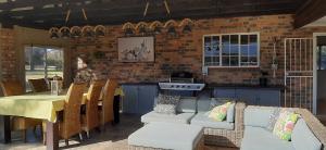 a living room with a couch and a table at Mountains and More in Hekpoort