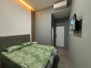 a bedroom with a bed and a flat screen tv at AJ Kost Homestay in Palembang