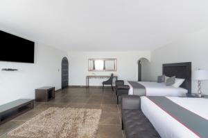 a hotel room with two beds and a flat screen tv at Hotel Boutique Nueva Escocia, Puebla in Puebla +47 photos