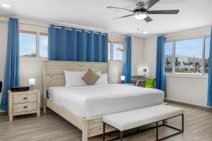 a bedroom with a large bed with blue curtains at Palm Beach Paradise by Bocobay in Palm-Eagle Beach +29 photos