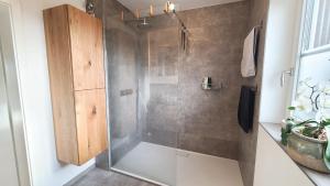 a shower with a glass door in a bathroom at Ferienwohnung mit Herz Chiemsee in Chieming