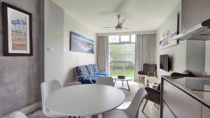 ein Wohnzimmer mit einem weißen Tisch und Stühlen in der Unterkunft La Ballito 107 in Ballito