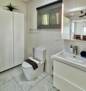 a white bathroom with a toilet and a sink at Villa Miyoko Ko Yao Noi Enjoy nature's beauty and stunning sunsets in Ko Yao Noi