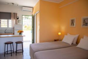 a hotel room with a bed and a kitchen at Stefanie Studios in Egina